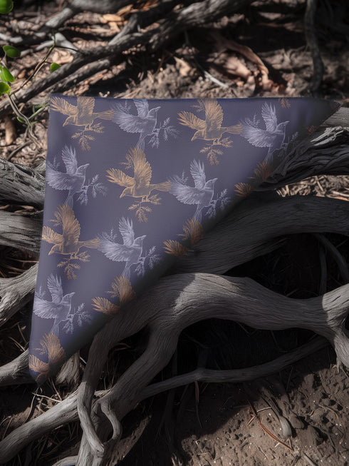 Set of four slate blue dining napkins featuring alternating gold and silver ravens in flight with botanical accents, sized 18x18 inches.
